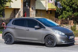 lato turchia 01 marzo 2022 silver peugeot 208 è parcheggiata sulla strada in una calda giornata estiva sullo sfondo di un edificio, giardino foto