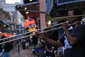 12 aprile 2015 - new orleans, louisiana, stati uniti - musicisti jazz che si esibiscono nel quartiere francese di new orleans, louisiana, con folle e luci al neon sullo sfondo. foto