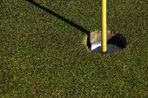 campo da golf con bandiera in una giornata di sole foto