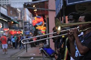 12 aprile 2015 - new orleans, louisiana, stati uniti - musicisti jazz che si esibiscono nel quartiere francese di new orleans, louisiana, con folle e luci al neon sullo sfondo. foto