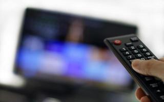 telecomando e schermo - abbuffarsi di guardare il programma televisivo preferito foto