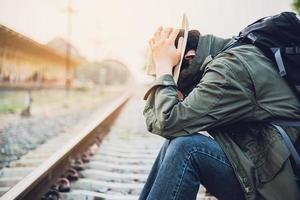 uomo di viaggio in attesa del treno alla piattaforma - attività di stile di vita di vacanza della gente al concetto di trasporto della stazione ferroviaria foto