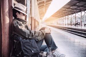 uomo di viaggio in attesa del treno alla piattaforma - attività di stile di vita di vacanza della gente al concetto di trasporto della stazione ferroviaria foto