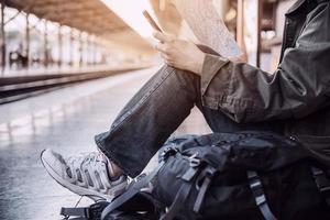 uomo di viaggio in attesa del treno alla piattaforma - attività di stile di vita di vacanza della gente al concetto di trasporto della stazione ferroviaria foto