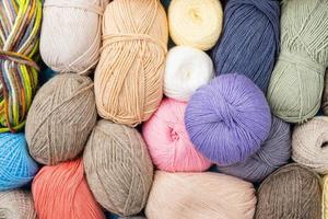 filato di lana color pastello sulla vetrina. sfondo di lavoro a maglia, un sacco di palle. filato per maglieria per abiti invernali fatti a mano foto