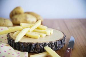 bastoncino di patate affettato pronto per fare patatine fritte - concetto tradizionale di preparazione del cibo foto