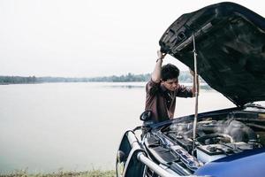 l'uomo cerca di risolvere un problema al motore di un'auto su una strada locale chiang mai thailandia - persone con problemi di auto concetto di trasporto foto