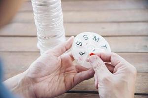 le persone preparano la compressa quotidiana della medicina nel portapillole - assistenza sanitaria della gente con il concetto delle pillole della medicina foto