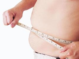 l'uomo grasso sta misurando la sua pancia usando un metro a nastro - concetto di salute alimentare foto