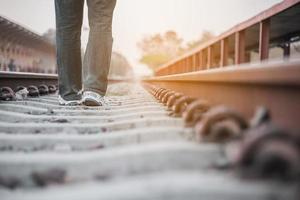 uomo di viaggio in attesa del treno alla piattaforma - attività di stile di vita di vacanza della gente al concetto di trasporto della stazione ferroviaria foto