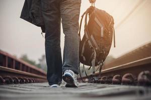 uomo di viaggio in attesa del treno alla piattaforma - attività di stile di vita di vacanza della gente al concetto di trasporto della stazione ferroviaria foto