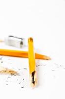 matita, temperamatite in metallo e trucioli di matita su sfondo bianco. immagine verticale. foto