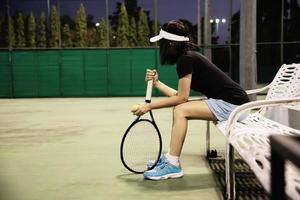 donna triste tennista seduta in tribunale dopo aver perso una partita - persone nel concetto di gioco di tennis sportivo foto