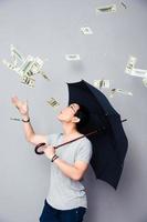 uomo asiatico in piedi sotto la pioggia di soldi foto