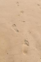 impronte umane sulla sabbia della spiaggia