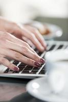 mani di donna digitando su una tastiera foto