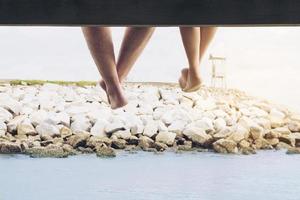 gamba di coppia appesa felicemente durante la loro vacanza sul ponte del mare foto