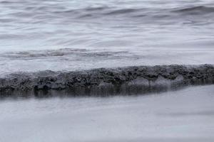 fuoriuscita di petrolio greggio sulla spiaggia foto