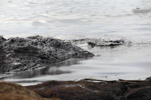 fuoriuscita di petrolio greggio sulla spiaggia foto