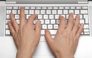 mani femminili che stampano sulla tastiera un computer portatile