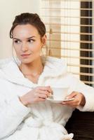 donna che beve il tè prima del trattamento foto