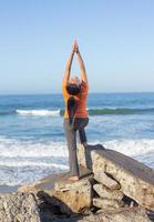 donna caucasica a praticare yoga in riva al mare