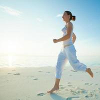 donna caucasica fare jogging in riva al mare