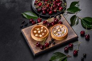 delizioso torrone fresco e crostata di noci con frutti di bosco freschi su un tagliere di legno foto