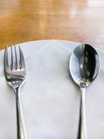 piatto bianco con il cucchiaio e la forchetta d'argento. foto