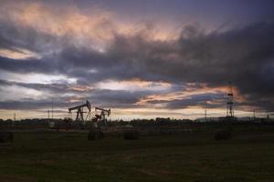 industria petrolifera. piattaforme petrolifere. pompe dell'olio al tramonto. copia spazio. foto