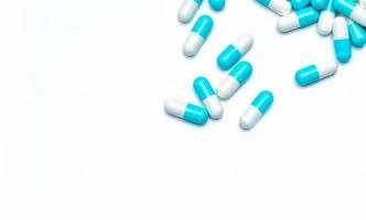 pillole di capsule antibiotiche blu-bianche su sfondo bianco. pillole colorate per l'argomento sanitario. industria farmaceutica. concetto di resistenza ai farmaci antibiotici. farmaco antimicrobico. farmaceutici. foto
