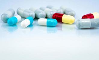 capsule colorate su sfondo bianco. industria farmaceutica. interazione fitoterapica con altri farmaci. farmaceutici. concetto di farmacia farmacia. capsule blu, bianche, rosse e gialle. foto
