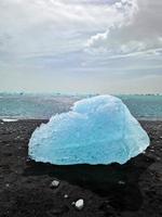 Diamond Beach in Islanda con iceberg blu che si sciolgono sulla sabbia nera e ghiaccio che brilla di luce solare foto