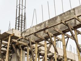 cantiere in loco che mostra trave e colonna con barre in acciaio rinforzato e struttura di rinforzo in legno foto