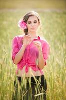 ragazza in rosa sul campo di grano dorato