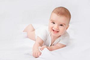 neonato sorridente sveglio su priorità bassa bianca foto