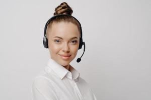 bellissimo consulente di call center in camicia bianca con auricolare nero foto