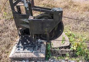 vecchia puleggia in acciaio con il filo metallico del palo del segnale stradale. foto