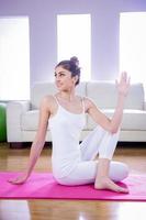 donna adatta che fa yoga sulla stuoia foto