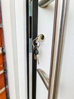 aprire la porta dell'appartamento con una chiave nella serratura: sicurezza e protezione contro i furti. foto