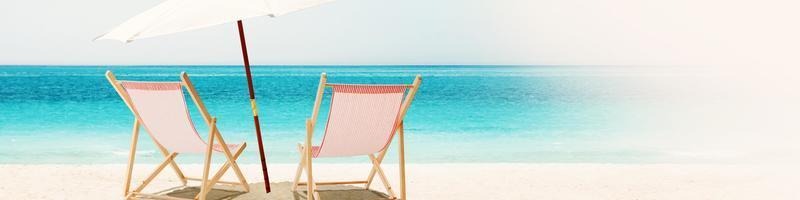 rilassarsi sulla spiaggia tropicale al sole sulle sedie a sdraio. foto