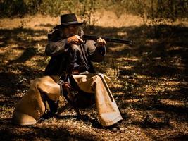 un anziano cowboy sedeva con una pistola a guardia della sicurezza del campo nell'area occidentale foto