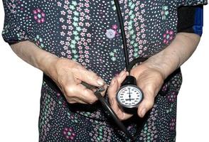una donna anziana misura la sua pressione con un tonometro foto