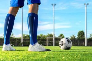 calciatore professionista o giocatore di calcio calcia e tira la palla su rigore o punizione al portiere per aver vinto il gol del campione nella finale di campionato nello stadio sul campo foto