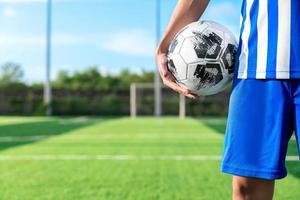 calciatore professionista o giocatore di calcio calcia e tira la palla su rigore o punizione al portiere per aver vinto il gol del campione nella finale di campionato nello stadio sul campo foto