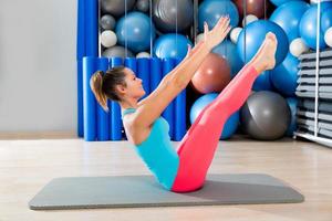 Pilates teaser esercizio donna sulla stuoia palestra coperta foto
