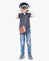la foto d'annata del ragazzo asiatico del viaggiatore di 7 anni sta usando il binocolo