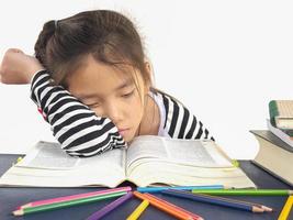 il bambino asiatico sta dormendo mentre legge un grande libro foto