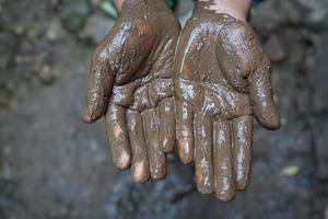 le mani del bambino piene di fango foto