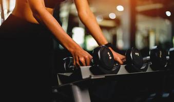 ragazza fitness con manubri in palestra foto ravvicinata concetto di salute e bellezza degli amanti della salute.